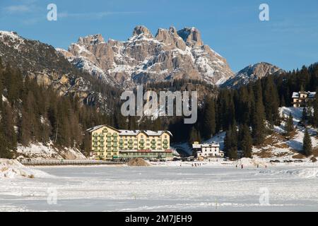 AURONZO DI CADORE, ITALIEN - 29. DEZEMBER 2022: Blick auf den Misurina-See in der Wintersaison mit Schnee, dem größten natürlichen See der Cadore und darüber Stockfoto