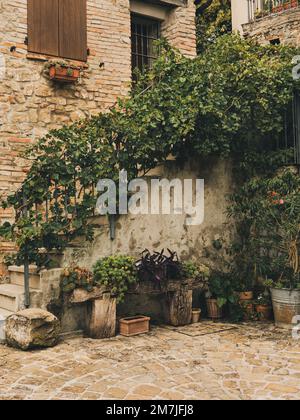 Italienisches traditionelles borgo. Balkon mit landschaftlich schönen Blumen. Ein Stück des italienischen alten Dorfes mit Blumen und Blumentopf Stockfoto