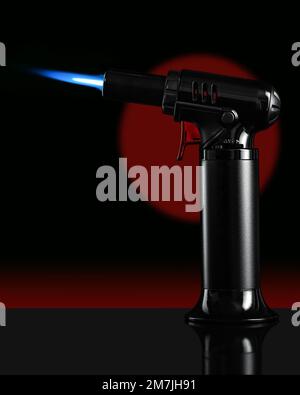 Eine Gasbrennerküche mit blauer Flamme auf schwarzem Hintergrund. Stockfoto