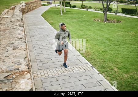 Fitness, Laufen und Black man Runner im Park für körperliches Training und Training, Cardio und Energie. Marathontraining, Laufen und Sportmotivation Stockfoto