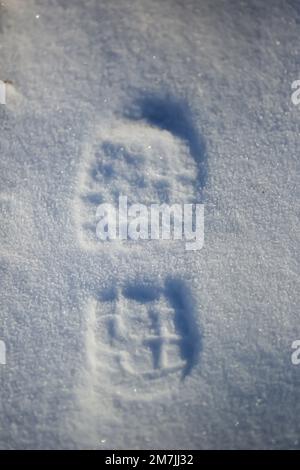 Nahaufnahme eines Schuhabdrucks im Schnee, Ansicht von oben eines Schuhabdrucks Stockfoto