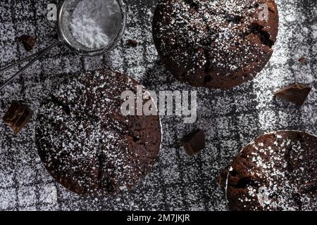 Frisch gebackene Schokoladen-Muffins auf dunklem Hintergrund. Stockfoto