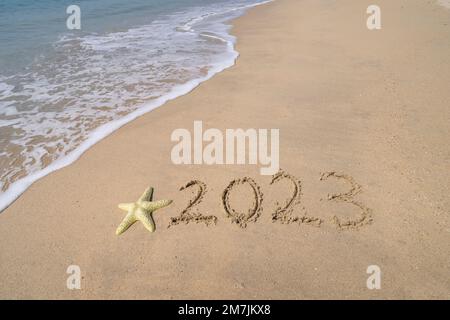 2023 handgeschrieben mit Seesternen im Sand an einem wunderschönen Strand Stockfoto