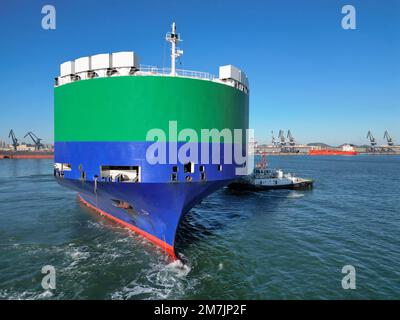 YANTAI, CHINA - 10. JANUAR 2023 - Ein Auto-Ro-Schiff, unterstützt von Schleppbooten, fährt vom Hafen von Yantai, Ost-Chinas Provinz Shandong, am 9. Januar 202 ab Stockfoto