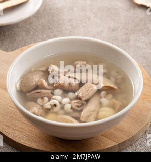 Four Tonics Suppe. Köstliches hausgemachtes taiwanesisches traditionelles chinesisches Kräutergericht mit Kräutern, Schweinedärm auf grauem Tischhintergrund Stockfoto