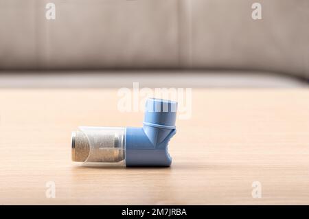 Nahaufnahme von Asthma-Inhalatoren mit leerem Etikett auf Holztisch. Pharmazeutisches Produkt wird zur Behandlung von Lungenentzündungen und zur Vorbeugung von Asthmaanfällen bei AS angewendet Stockfoto