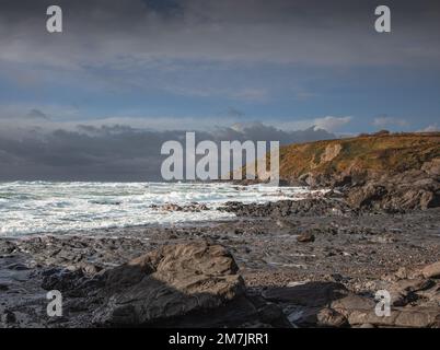 Ein Sturm nähert sich einem felsigen Cornish Beach in Dollar Cove The Lizard Stockfoto