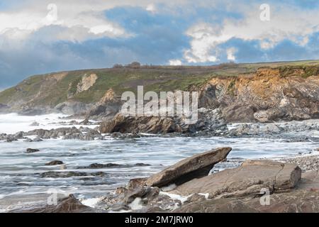 Ein Sturm nähert sich einem felsigen Cornish Beach in Dollar Cove The Lizard Stockfoto