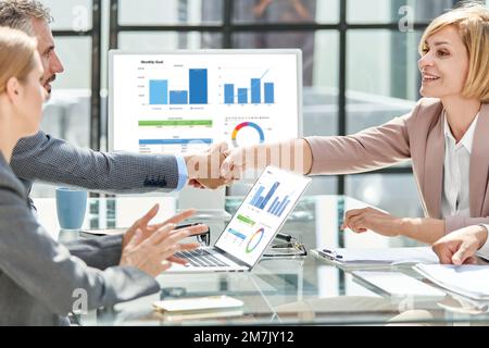 Geschäftsmann und Geschäftsfrau, die sich die Hand schütteln. Zum Begriff des Genossenschaftswesens Stockfoto