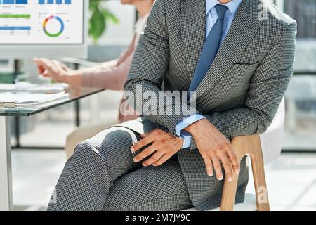 Geschäftsmann sitzt in einem Bürostuhl. Stockfoto