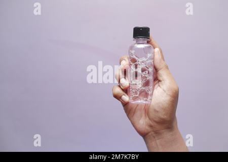 Halten Sie einen Behälter für Mundwasser mit der Hand Stockfoto