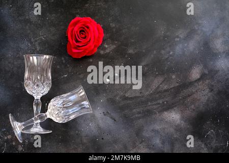 Zwei Gläser mit roter Rose in der Nähe auf dunklem Hintergrund Stockfoto