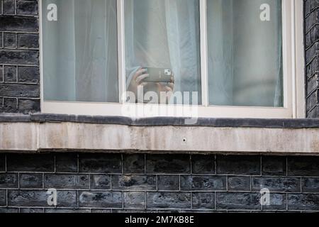 Ein Mitarbeiter fotografiert Handyfotos durch ein Fenster über der 10 Downing Street, London, England, Großbritannien Stockfoto