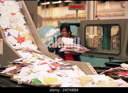 Postangestellter in den späten 1990er Jahren, der die ankommende Weihnachtspost im Sortierbüro Mount Pleasant im Zentrum von London, England, Großbritannien, sortierte Stockfoto