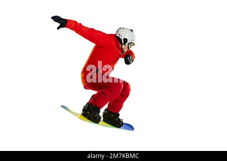 Ich mache Tricks. Porträt eines aktiven Mannes, Snowboarders in Uniform, der auf einem Snowboard fährt, isoliert vor weißem Studiohintergrund. Konzept des Wintersports Stockfoto