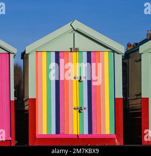 Bunte bemalte Streifen auf einer Strandhütte entlang der Küste von Hove , Sussex , England , Großbritannien Stockfoto