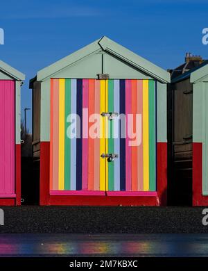 Bunte bemalte Streifen auf einer Strandhütte entlang der Küste von Hove , Sussex , England , Großbritannien Stockfoto