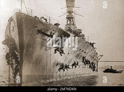 Ein 1930-Bild von Matrosen auf HMS Repulse, die den Rumpf reinigen und neu lackieren mit Schlachtschiff-grauer Farbe. Stockfoto