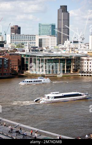 Flussrundfahrten Auf Der Themse Von London. Flussboote bringen Touristen durch die britische Hauptstadt vorbei an den Wolkenkratzern des Finanzviertels. Stockfoto