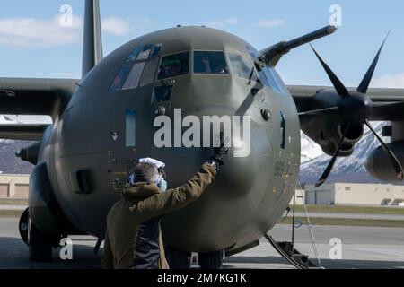 Ein Royal Air Force-Ladermeister, der der 47. Staffel, RAF Brize Norton, England, zugeteilt ist, kommuniziert mit C-130J Hercules-Piloten während DER RED FLAG-Alaska 22-1 auf der Joint Base Elmendorf-Richardson, Alaska, 10. Mai 2022. Es wird erwartet, dass etwa 2.200 Mitglieder aus den USA, Großbritannien und Kanada während dieser Übung mehr als 90 Flugzeuge aus über 25 Einheiten fliegen, warten und unterstützen. Stockfoto