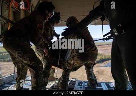 Soldaten der britischen Armee führen einen Luftabwurf aus einer Royal Air Force C-130J Hercules aus, die der 47. Staffel, RAF Brize Norton, England, zugeteilt wurde, während DER RED FLAG-Alaska 22-1 über der Joint Base Elmendorf-Richardson, Alaska, 10. Mai 2022. RF-A ist eine von den pazifischen Luftwaffen ausgerichtete Feldübung, die es den Streitkräften ermöglicht, Interoperabilität zu praktizieren, indem sie einzigartige Möglichkeiten bietet, sich in gemeinsame und multilaterale Schulungen zu integrieren. Stockfoto