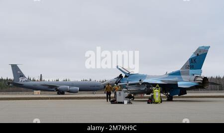 EIN US-AMERIKANISCHER Air Force KC-135 Stratotanker, der dem 168. Air Tanken Flügel zugeteilt wurde, startet von der Start- und Landebahn, während Airmen, die der 18. Aircraft Maintenance Unit zugeteilt sind, während DER RED FLAG Alaska 22-1, 10. Mai 2022, Flugvorbereitungen am Eielson Air Force Base, Alaska, durchführen. Diese Übung verstärkt das anhaltende Engagement der Vereinigten Staaten für die Region als pazifische Nation, Führer und Macht. Stockfoto