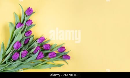 Wunderschöner romantischer Strauß rosa Tulpen auf gelbem Hintergrund. Viele Tulpen, großer Strauß. Valentinstag, Frauen- oder Muttertag feiern Stockfoto