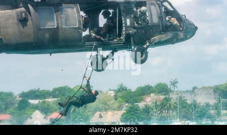 Ein kolumbianischer Marine klettert auf eine Leiter, die an eine US-amerikanische angeschlossen ist Army Sikorsky UH-60 Black Hawk Helikopter während Helocast-Extraktionsübungen während der Übung Tradewinds 2022 (TW22) in der Bacalar Lagune, Mexiko, 10. Mai 2022. TW22 ist ein US-amerikanisches Vom Kommando Süd finanzierte multidimensionale Übung mit Schwerpunkt auf der Karibik, die in den Bereichen Boden, Luft, Meer und Cybersicherheit durchgeführt wird und den teilnehmenden Nationen die Möglichkeit bieten soll, gemeinsame, kombinierte und interinstitutionelle Schulungen durchzuführen, die auf die Verbesserung der regionalen Zusammenarbeit und Interoperabilität bei komplexen multinationalen Sicherheitseinsätzen ausgerichtet sind. Stockfoto