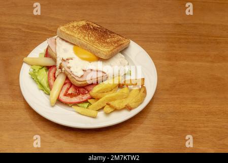 Doppeldecker-Sandwich mit Spiegelei, Schinken, Toast, Tomatenscheiben, weißem Spargel in der Dose und Pommes frites Stockfoto