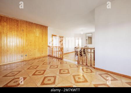 Wohn- und Esszimmer in doppelter Höhe mit einer Wand aus Kiefernholz und dazu passenden alten Steinbodenbelägen Stockfoto