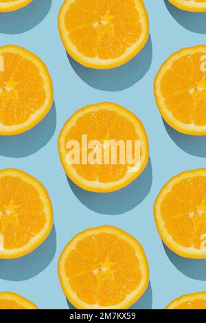 Muster aus frischen orangefarbenen Hälften auf blauem Hintergrund. Minimalfrucht-Konzept. Stockfoto