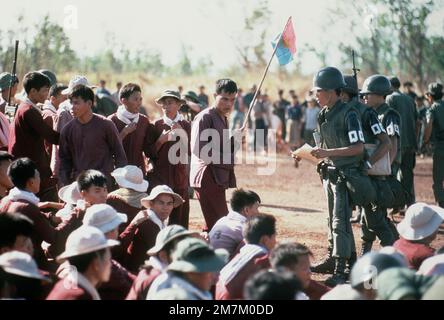 Vietcong-Gefangener, einer mit Vietcong-Flagge, stehen und sitzen am Austauschort. Sie wurden mit einem Flugzeug der USAF C-130 vom Luftwaffenstützpunkt Bien Hoa eingeflogen. Sie werden gegen amerikanische und südvietnamesische Kriegsgefangene ausgetauscht, die von den Vietcong-Streitkräften festgehalten werden. Subjekt Operation/Serie: HOMECOMING-Basis: Loc Ninh Country: South Vietnam Stockfoto