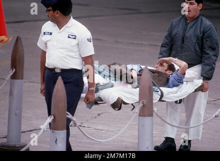 Ehemaliger Kriegsgefangener und USA Air Force TSGT James R. Cook begrüßt die Farben seiner Trage, die er aus dem C-141-Flugzeug trägt. TSGT Cook wurde am 21. Dezember 72 gefangen genommen und am 12. Februar 73 von den Nordvietnamesen in Hanoi freigelassen. Betreff Operation/Serie: HOMECOMING Base: Naval Air Station, Alameda Staat: Kalifornien (CA) Land: Vereinigte Staaten von Amerika (USA) Stockfoto