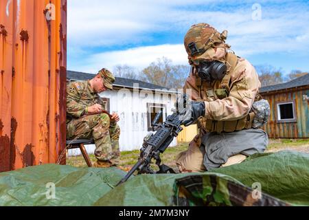 USA Army Sgt. Jordan Vorse, ein Chemie-, Biologie-, Radiologie- und Nuklearspezialist, der dem 15. Civil Support Team, der Vermont Army National Guard, zugeteilt ist, zerlegt eine M249 Squad Automatic Weapon, während sie von den USA bewertet wird Army Staff Sergeant Michael Landon, ein Infanterie-Mann, dem 102. Infanterie-Regiment zugeteilt, Connecticut Army National Guard, Stones Ranch Military Reservation, East Lyme, Connecticut, 10. Mai 2022. Die Soldaten mussten die Waffe zerlegen und wieder zusammensetzen, während sie Schutzkleidung gegen chemische und biologische Agenzien trugen, die auch als missionsorientierte Schutzhaltung bekannt ist, oder Stockfoto