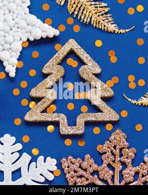 Banner mit goldenen und weißen Dekorationen für den Weihnachtsbaum. Dekorative Neujahrssterne und Schneeflocken auf klassisch blauem Hintergrund. Stockfoto
