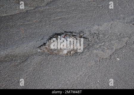 Ein Schlagloch in einer Stadtstraße Stockfoto