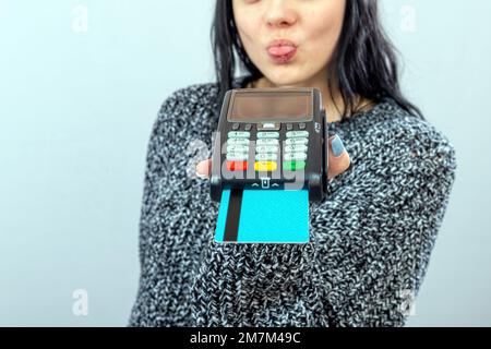 Frau hält ein Zahlungsterminal und zeigt ihr kontaktloses Zahlungskonzept Stockfoto