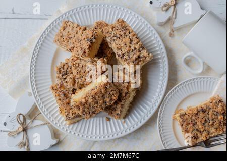 Nusskuchen mit Haselnüssen und osterdekoration auf weißem Hintergrund. Flach verlegt Stockfoto