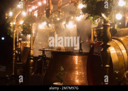 Ein Marktstand auf dem Winchester Christmas Market, der Glühwein oder Gewürzwein oder Gluwhein in Kupferfässern verkauft, gedeckt in Steam, Winchester, Großbritannien Stockfoto