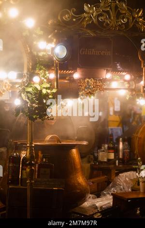 Ein Marktstand auf dem Winchester Christmas Market, der Glühwein oder Gewürzwein oder Gluwhein in Kupferfässern verkauft, gedeckt in Steam, Winchester, Großbritannien Stockfoto