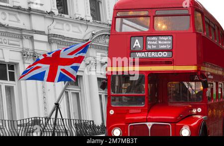 Ein alter alter Doppeldeckerbus mit offenem Oberdeck mit Ziel Waterloo vor der Flagge des Vereinigten Königreichs, die auf einem weißen viktorianischen Gebäude winkt. Stockfoto