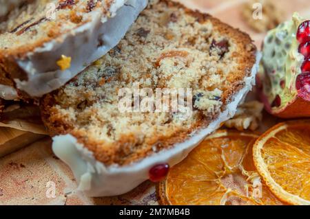 Weihnachtsstollen mit kandierten Früchten und getrockneten Früchten auf Pergament. Stollen: Traditionelles deutsches Brot, das in der Weihnachtszeit gegessen wird. Stollen auf w Stockfoto
