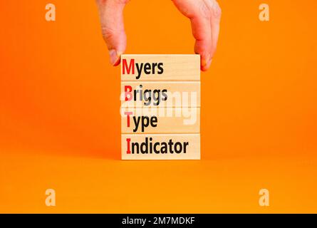 Anzeigesymbol des Typs MBTI Myers Briggs. Konzeptbegriffe MBTI Myers Briggs-Indikator auf Block auf schönem orangefarbenen Hintergrund. Psychologische MBTI My Stockfoto