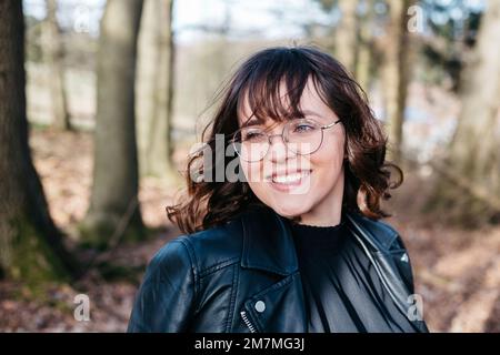 Lachende junge Frau im Wald Stockfoto