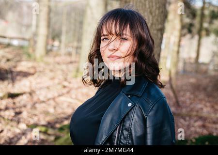 Anspruchsvolle junge Frau im Wald Stockfoto