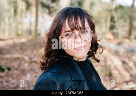 Lächelnde junge Frau im Wald Stockfoto