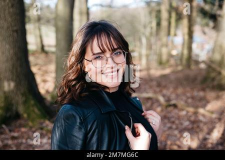 Glückliche lachende Frau im Wald Stockfoto