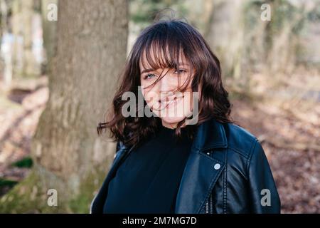 Glückliche lachende Frau im Wald Stockfoto