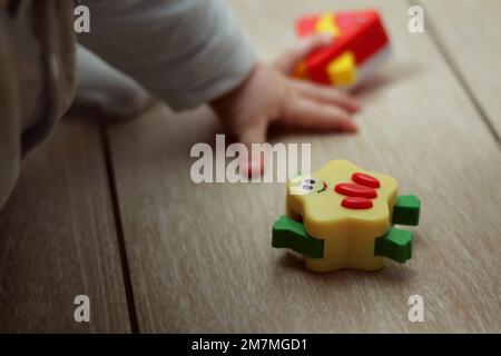 Pädagogisches Spielzeug für Kinder. Kinderhände auf unscharfem Hintergrund. Montessori-Spiele zur Kinderentwicklung Stockfoto