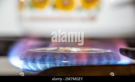 Die Flamme eines alten Gasherds brennt in einer Küche. Stockfoto